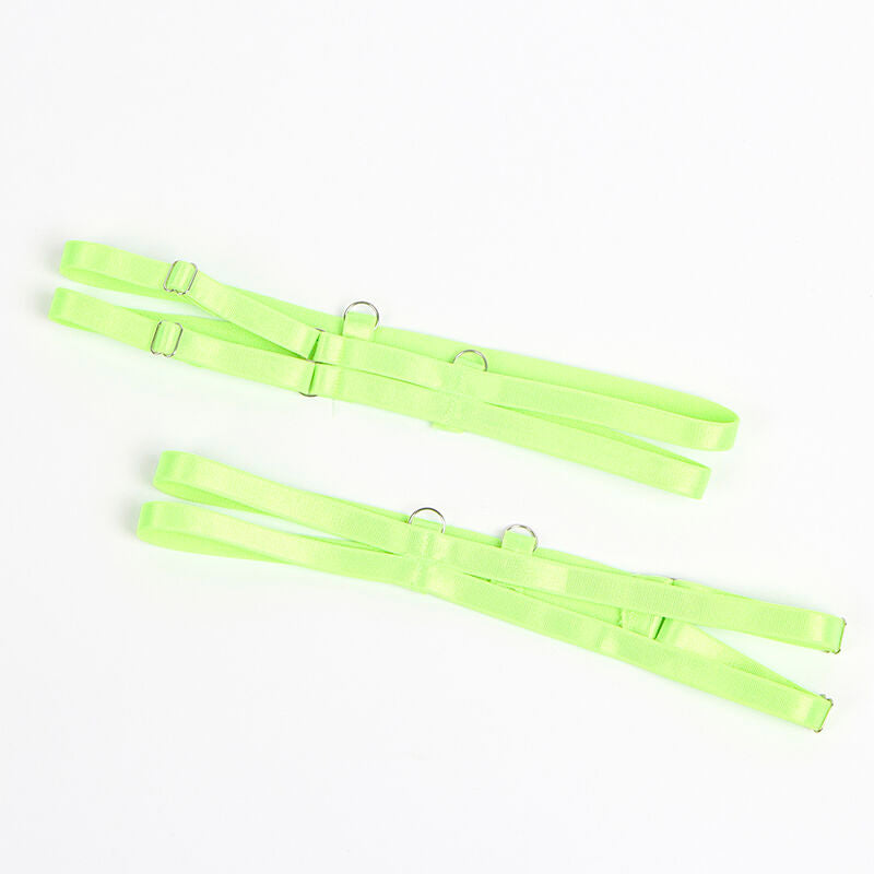 Paire de jarretieres de jambe ajustables en elastique vert fluo avec boucles metal, posees a plat sur fond blanc, accessoire de l'ensemble Subblime.
