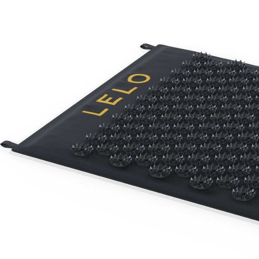 Tapis d acupression Lelo Come Together noir vu en plongee avec logo dore et picots reguliers, accessoire de massage corporel et relaxation sensorielle.
