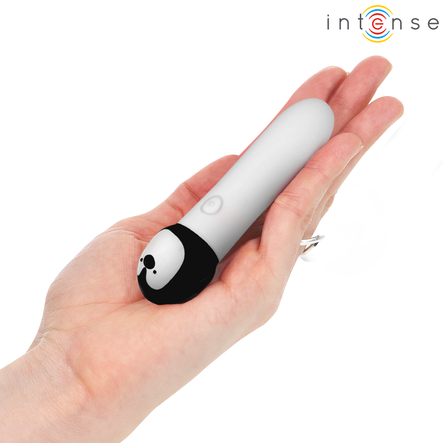 Mini vibromasseur bullet Intense Rico au design pingouin tenu dans la main pour montrer son format de poche, silicone blanc et noir ultra-doux.