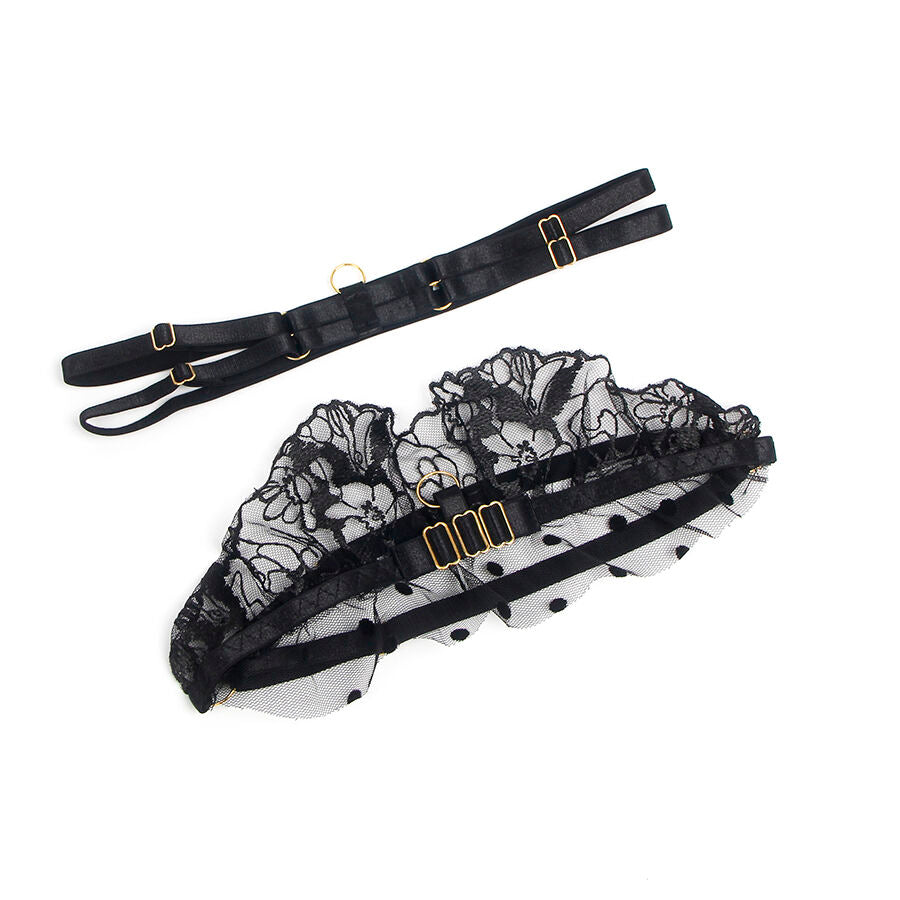 Porte-jarretelles dentelle noire Subblime presente a plat, volants en maille fleurie a pois et sangles ajustables a boucles dorees, piece d'une parure sensuelle.