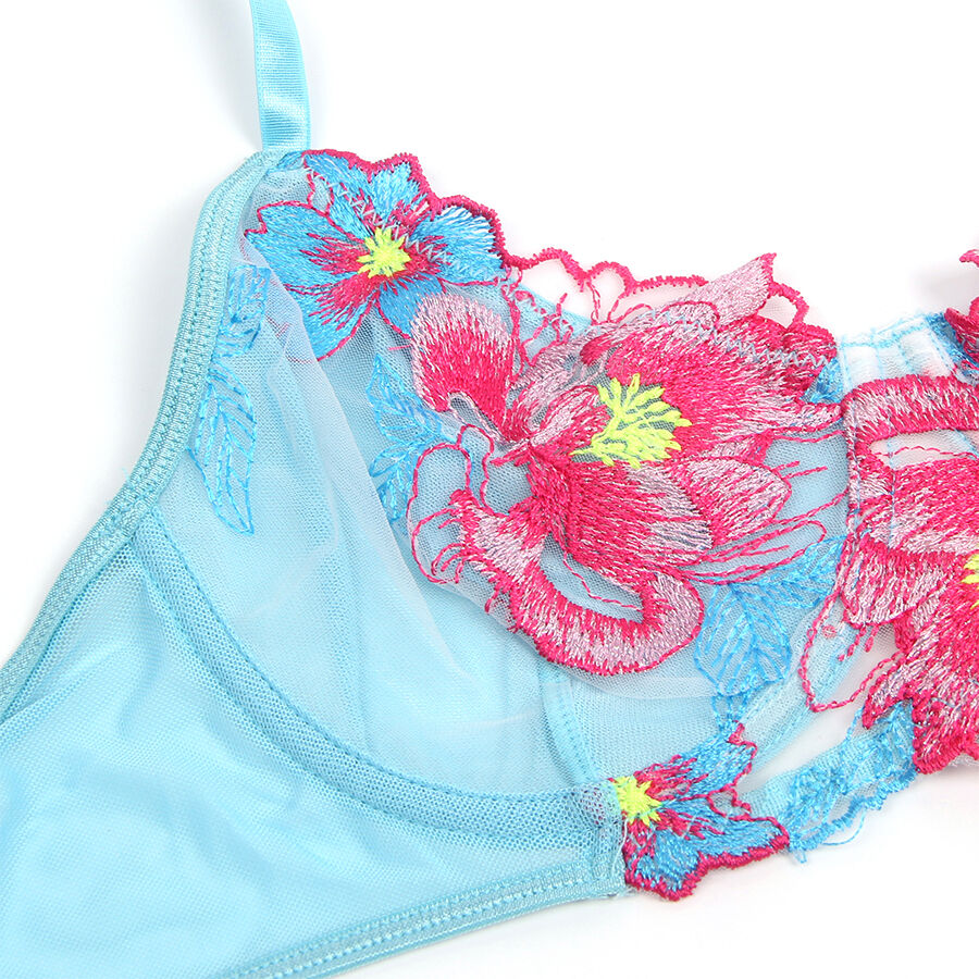 Gros plan sur la broderie florale rose vif et turquoise en relief du soutien-gorge en maille bleue Subblime, detail transparence presente sans corps.