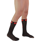Chaussettes hautes homme noires semi-transparentes de profil, logo Macho rouge en haut, maille fine fetichiste a effet seconde peau sur la jambe.