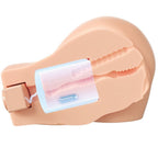 Masturbateur buste realiste en coupe laterale montrant le module vibrant et aspirant insere dans le tunnel, orifices moules teinte chair et fesses galbees en TPR.