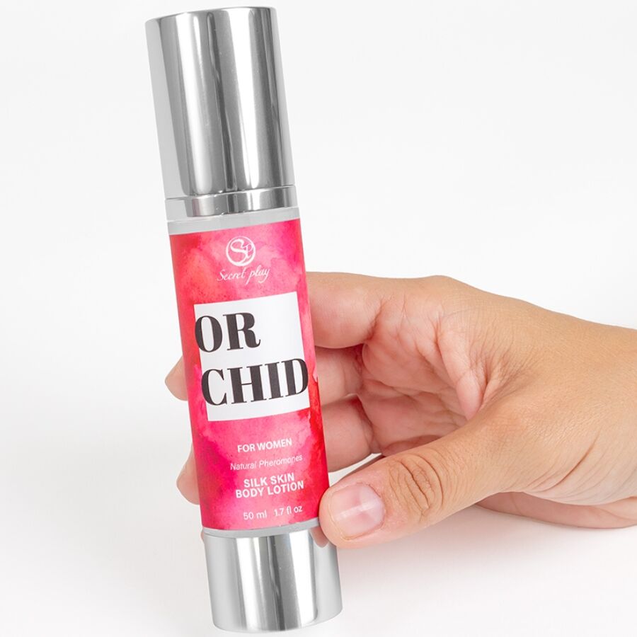 Flacon airless de lotion corporelle Orchid For Women Silk Skin tenu en main, soin hydratant soyeux aux pheromones Secret Play, etiquette rose vif.