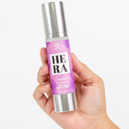 Flacon airless de lotion corporelle Hera For Women Silk Skin tenu en main, soin hydratant soyeux aux pheromones Secret Play, etiquette mauve.