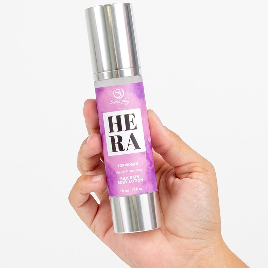 Flacon airless de lotion corporelle Hera For Women Silk Skin tenu en main, soin hydratant soyeux aux pheromones Secret Play, etiquette mauve.