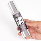 Flacon airless argente de la lotion Apolo pour homme Secret Play tenu en main, gros plan presentant la lotion soyeuse aux pheromones, format 50 ml hydratant masculin.