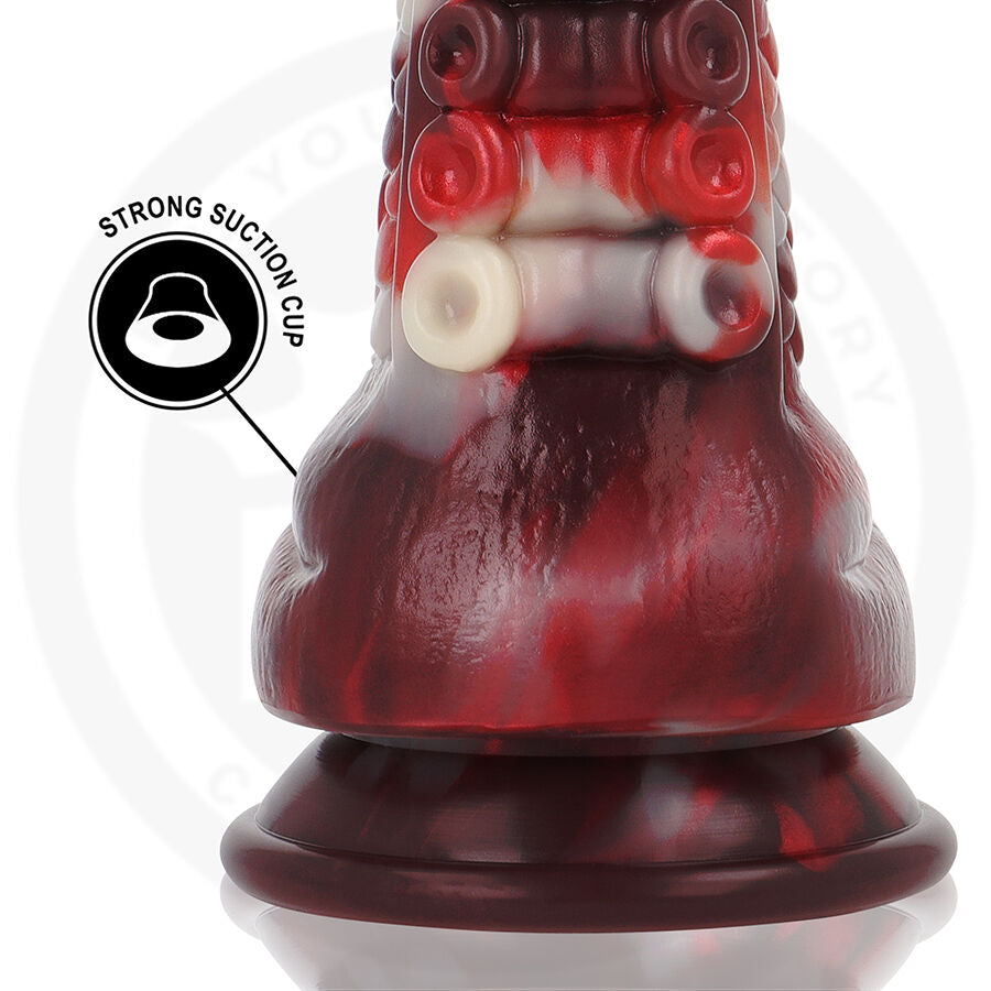 Detail de la base evasee rouge sombre du gode corne, anneaux blancs textures et pictogramme strong suction cup, silicone flexible pour fixation stable.
