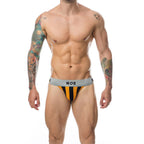 Jockstrap homme raye orange et noir MOB porte de face, ceinture grise logotee et pochette galbante, presente sur un torse masculin tatoue et muscle.