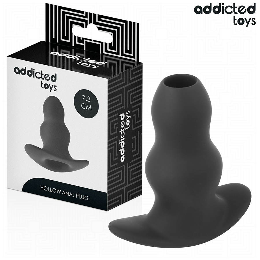 Plug anal creux Addicted en silicone noir 7,3 cm pres de sa boite, structure tunnel ouverte au centre et base evasee pour une sensation d'ouverture et de remplissage.