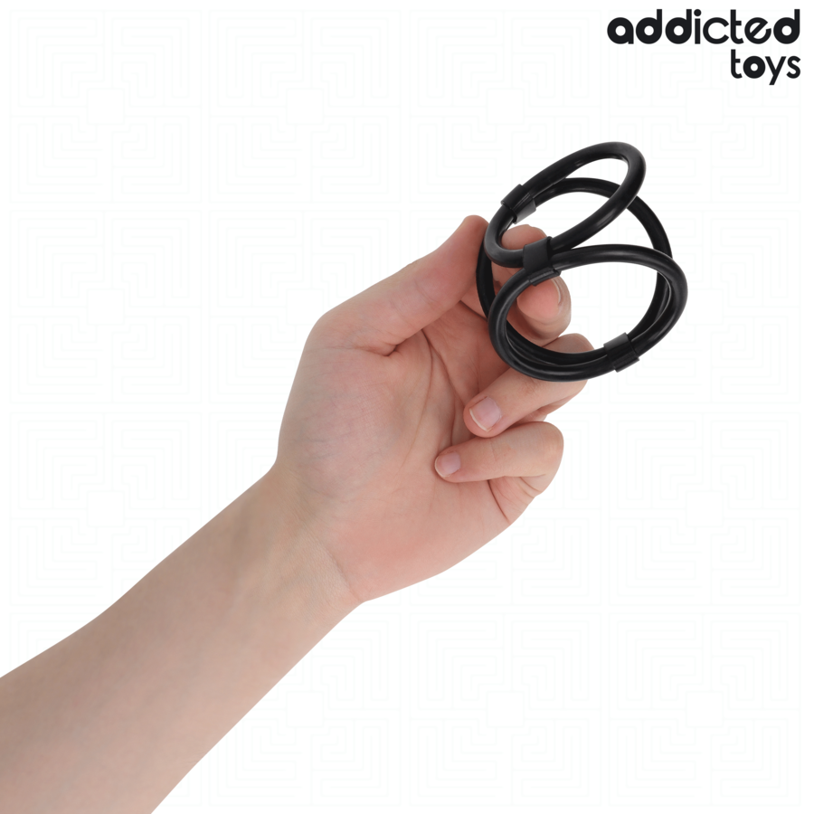 Triple anneau penien cordon en silicone noir Addicted tenu entre les doigts pour montrer ses boucles souples, cockring de maintien du penis et des testicules.