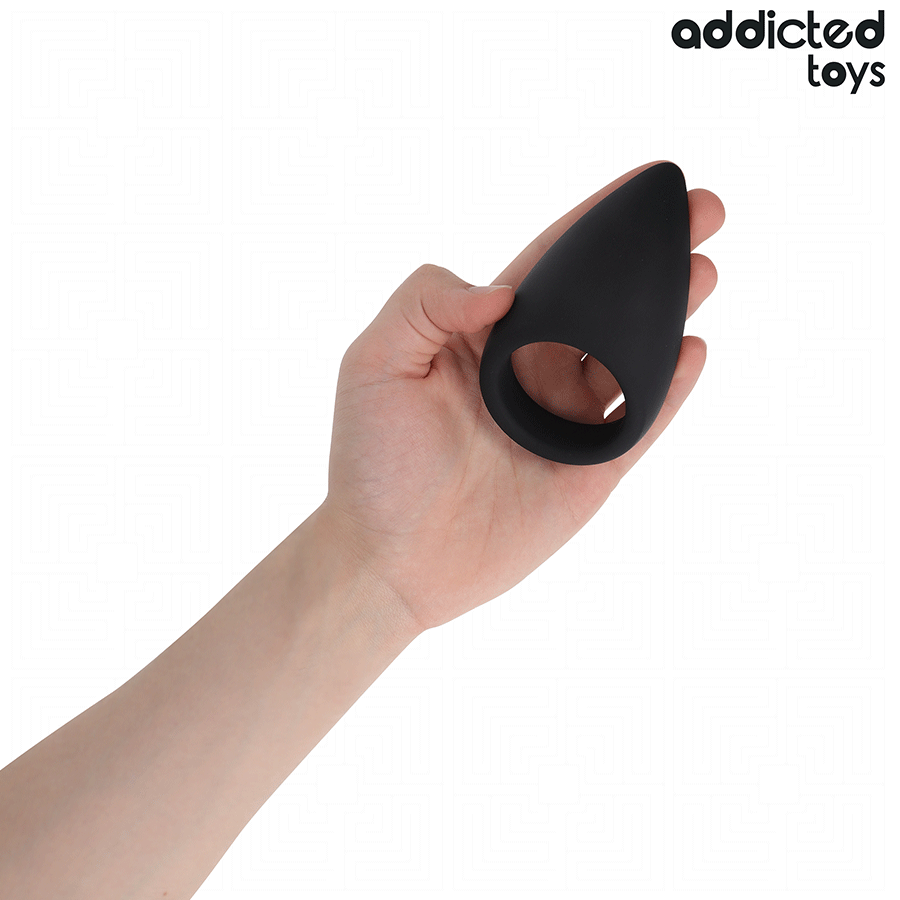 Anneau penien en forme de larme en silicone noir Addicted tenu au creux de la main pour illustrer sa taille compacte, cockring ergonomique de maintien.