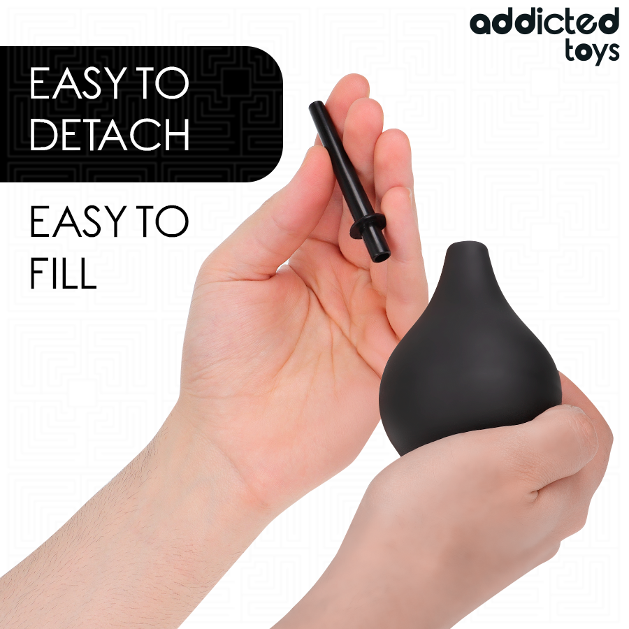 Poire de lavement Addicted detachable montree en main a cote de sa canule, illustrant le systeme easy to detach et easy to fill pour un remplissage rapide.