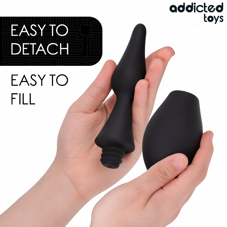 Poire de lavement intime Addicted demontee en main, canule separee du corps souple noir, systeme easy to detach easy to fill pour un entretien facile.