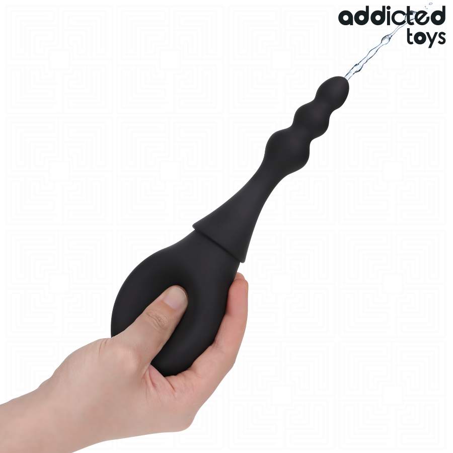 Poire de douche intime Addicted tenue en main, canule fine en silicone souple avec jet d'eau, format ergonomique facile a presser pour l'hygiene intime nomade.