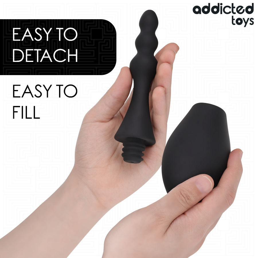 Poire de lavement intime Addicted demontee en main, canule separee de la poire souple noire, systeme easy to detach easy to fill pour un nettoyage pratique.