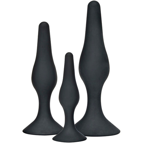 Kit de trois plugs anaux noirs en silicone aux tailles croissantes, vue de trois quarts. Design incurve a base evasee pour une progression douce du plus fin au plus large.