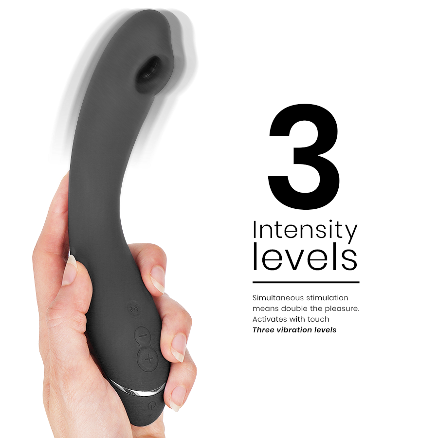 Stimulateur G-spot Womanizer OG noir tenu verticalement dans une main, corps courbé en silicone et tête à ondes d'air, visuel 3 niveaux de vibration. Format ergonomique compact.