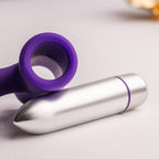 Anneau pénien violet en silicone posé à côté de sa balle vibrante argentée amovible, gros plan du cockring vibrant et de son moteur détachable Rocks-Off.
