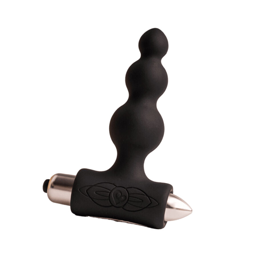 Plug anal à billes noires de taille croissante sur base vibrante en T, posé près d'un éclat doré, embout métallisé visible, silicone lisse sur fond neutre.