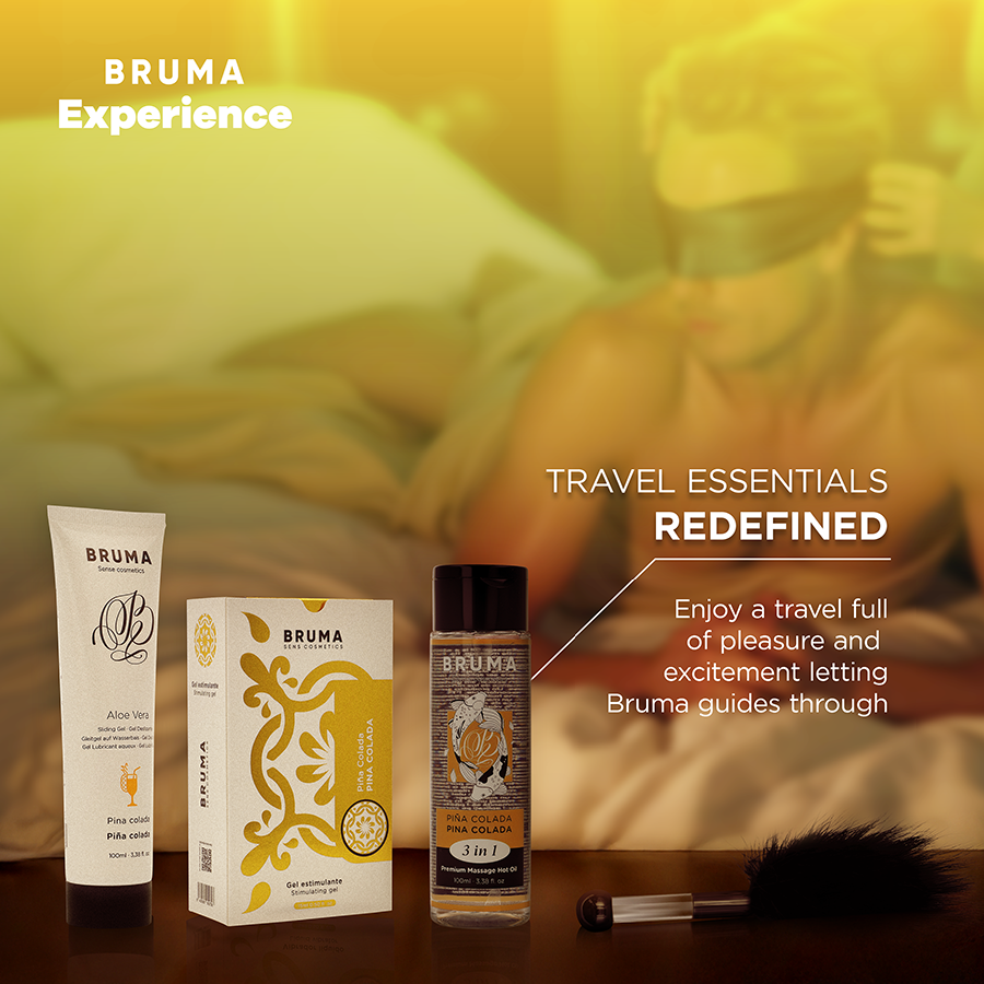 Tube et flacons du coffret pina colada Bruma en mise en scene voyage sur fond dore chaud, lubrifiant et huile de massage exotique, essentiels nomades tropicaux
