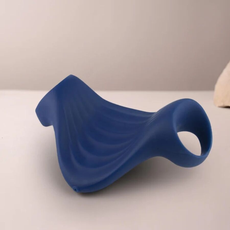 Masturbateur Palm bleu marine posé à plat sur un plan clair, gaine flexible en silicone nervuré avec passants, accessoire vibrant 10 modes étanche rechargeable.