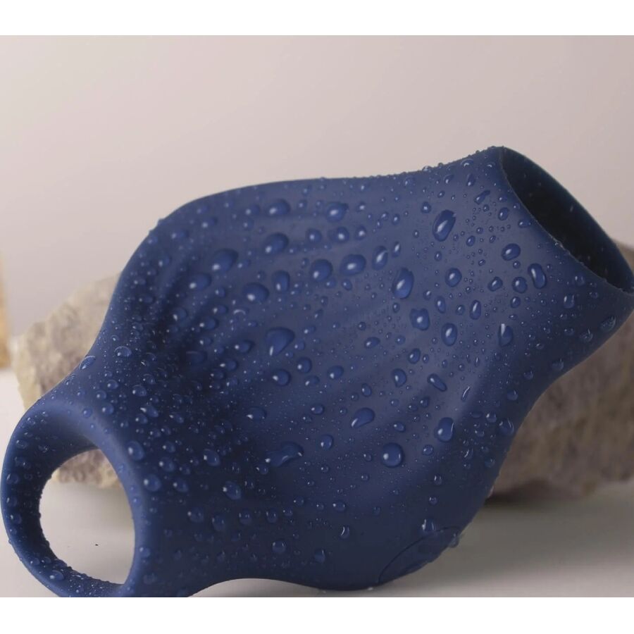 Gros plan du masturbateur Palm bleu marine couvert de gouttes d'eau, surface nervurée illustrant l'étanchéité de cette gaine vibrante flexible en silicone.