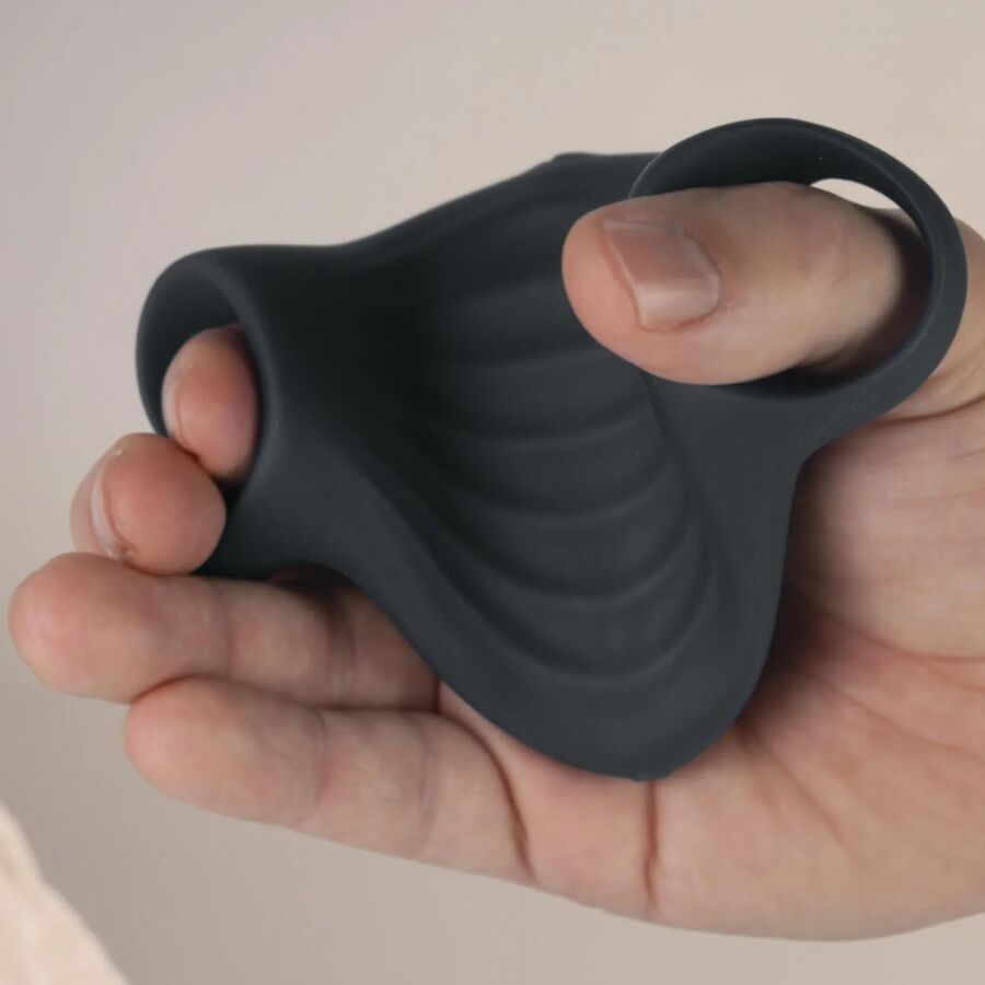 Masturbateur Palm noir tenu dans une main avec les doigts glissés dans les passants, illustrant la prise de cette gaine vibrante flexible en silicone.