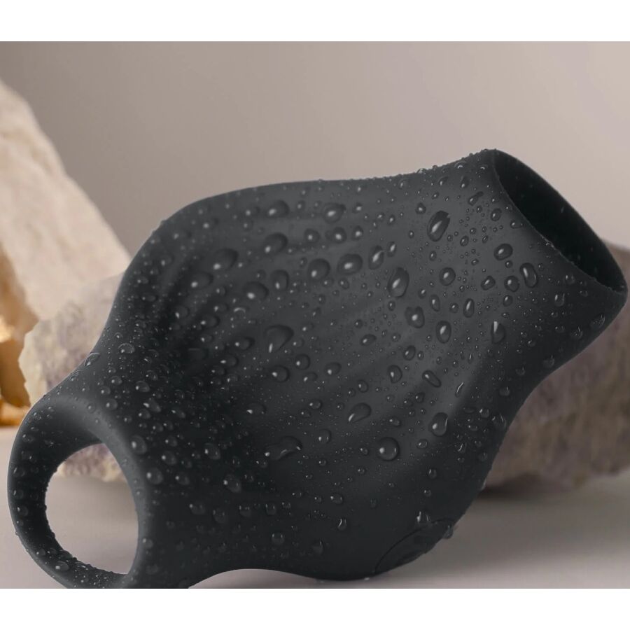 Gros plan du masturbateur Palm noir couvert de gouttes d'eau, surface en silicone nervurée illustrant l'étanchéité de cette gaine vibrante flexible rechargeable.