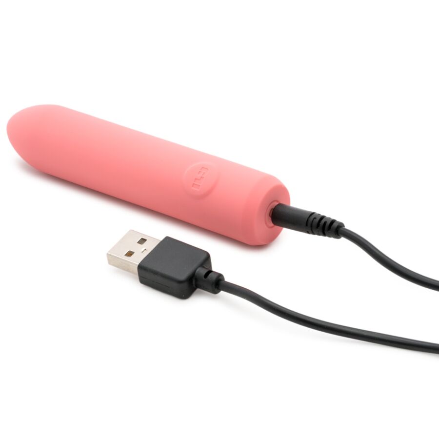 Bullet corail relié à un câble de charge USB noir branché, cylindre lisse posé à l'horizontale, illustration de la recharge USB du mini vibromasseur rechargeable sur fond blanc épuré.