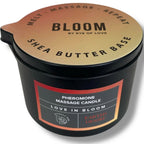Bougie de massage Earth's Desire vue de dessus, pot noir Pheromone Massage Candle au couvercle dore Shea Butter Base, cire boisee qui se transforme en huile de massage.