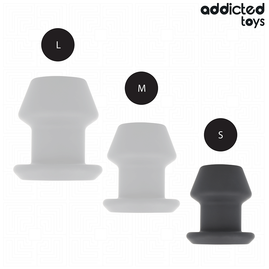 Trois tailles L, M et S du plug anal creux tunnel Addicted en silicone, du translucide au gris fonce, alignees pour comparer les diametres disponibles.