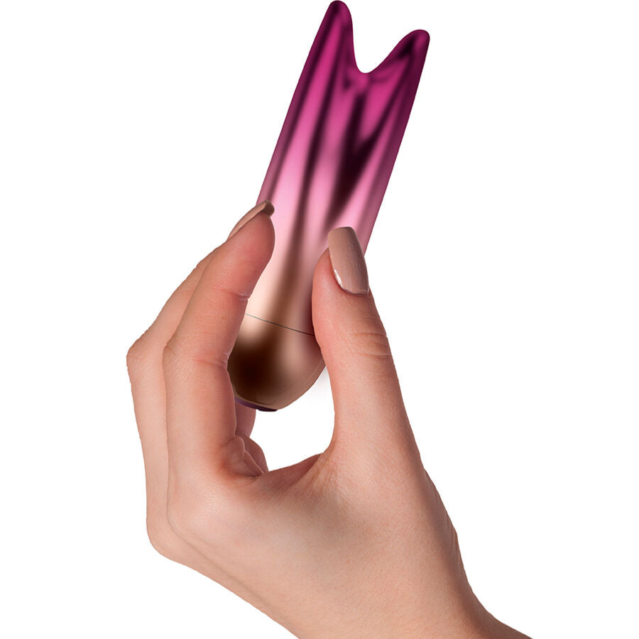 Mini vibromasseur double bullet Ava tenu entre les doigts, gros plan sur les deux extremites souples et le degrade prune dore, 10 niveaux d'intensite.