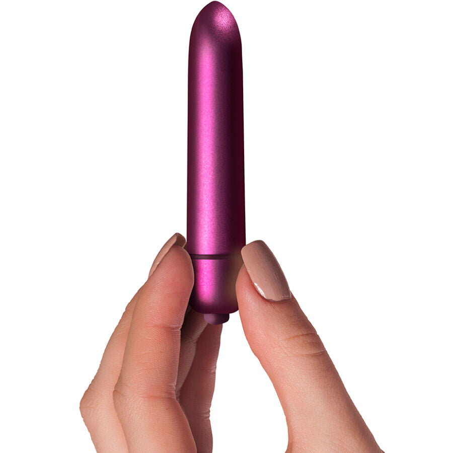 Mini vibromasseur bullet Jolie tenu entre les doigts, gros plan sur la finition prune brillante et le format discret de poche, 10 niveaux d'intensite.