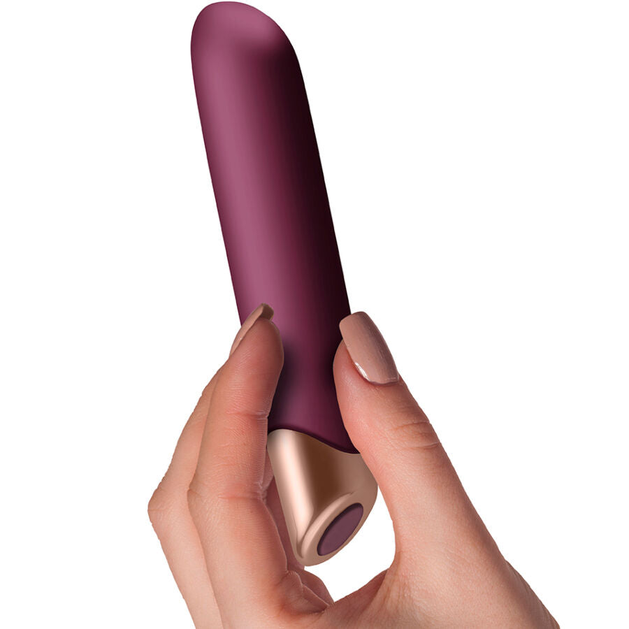 Vibromasseur classique Miyana tenu en main, gros plan sur la pointe conique prune et la base doree, format ergonomique a 10 niveaux puissants etanche.