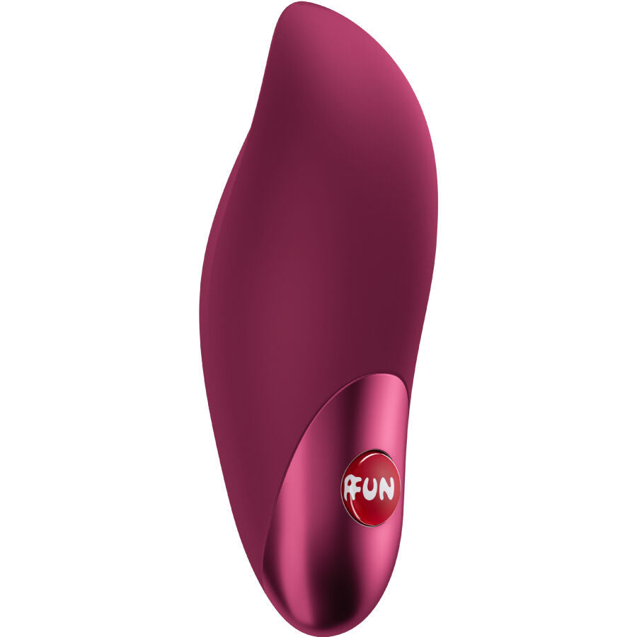 Mini vibromasseur Charme en silicone bordeaux vu de trois quarts couche, forme galet aux courbes sensuelles et bouton FUN rouge, rechargeable USB-C compact a douze niveaux.