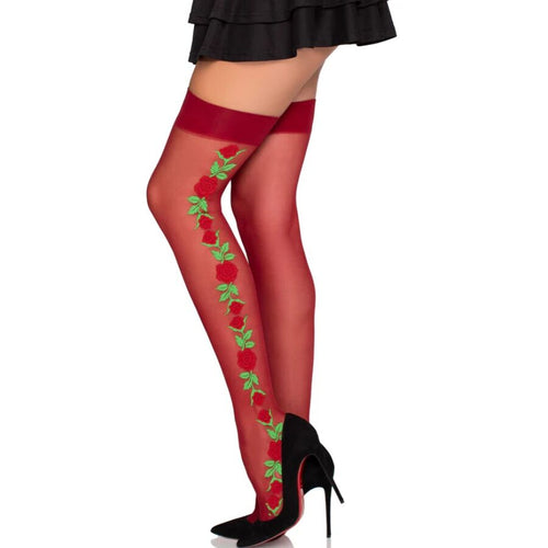 Bas rouges a motif de roses grimpantes vertes portes sur jambes nues avec escarpins noirs, detail floral graphique le long du mollet, style coquin.
