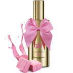 Flacon dore du gel Bubble Gum Bijoux Indiscrets avec noeud rose et eclaboussure de gel rose et bonbons, mise en scene gourmande du lubrifiant massage 2 en 1