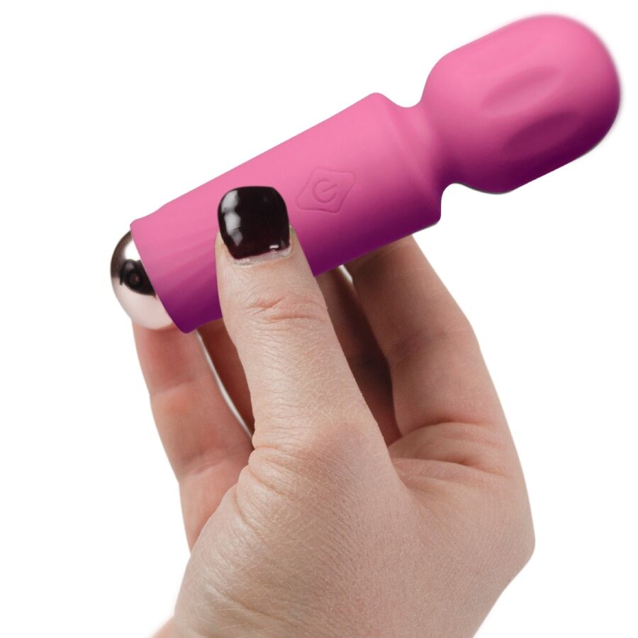 Mini wand vibrant rose tenu posé sur les doigts d'une main aux ongles vernis foncés, illustrant la taille de poche de ce vibromasseur rechargeable 16 fonctions.