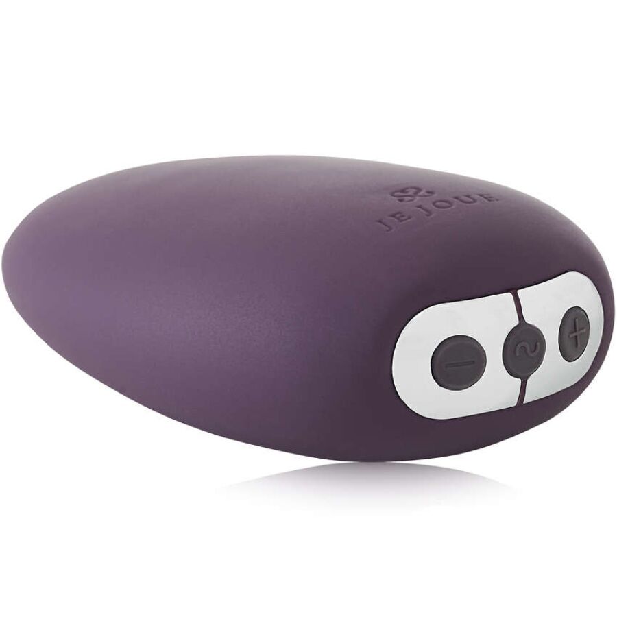 Vibrateur clitoral MiMi violet aubergine vu de trois quarts, galet en silicone doux avec trois touches argentées sur le côté, forme arrondie rechargeable et étanche.
