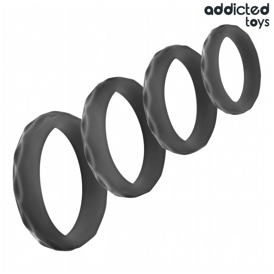 Les quatre anneaux peniens textures Addicted en silicone noir alignes en diagonale, surface striee et tailles croissantes pour soutenir et prolonger l'erection.