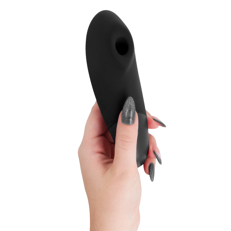 Main tenant le stimulateur clitoridien noir Womanizer Enhance de profil, embout de succion orienté vers le haut, corps galbé lisse en silicone, fond blanc épuré.