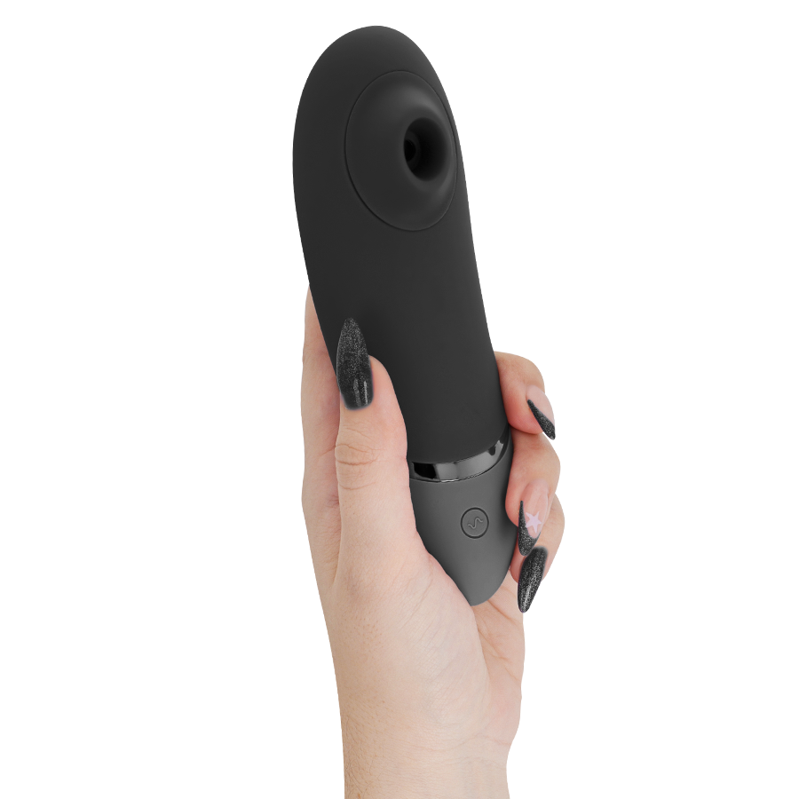 Womanizer Next noir tenu verticalement en main, embout d'aspiration clitoridien orienté vers le haut, stimulateur 3D Pleasure Air sans contact direct avec la peau.