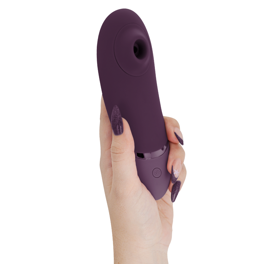 Womanizer Next aubergine tenu verticalement en main, embout d'aspiration clitoridien orienté vers le haut, stimulateur 3D Pleasure Air sans contact direct.