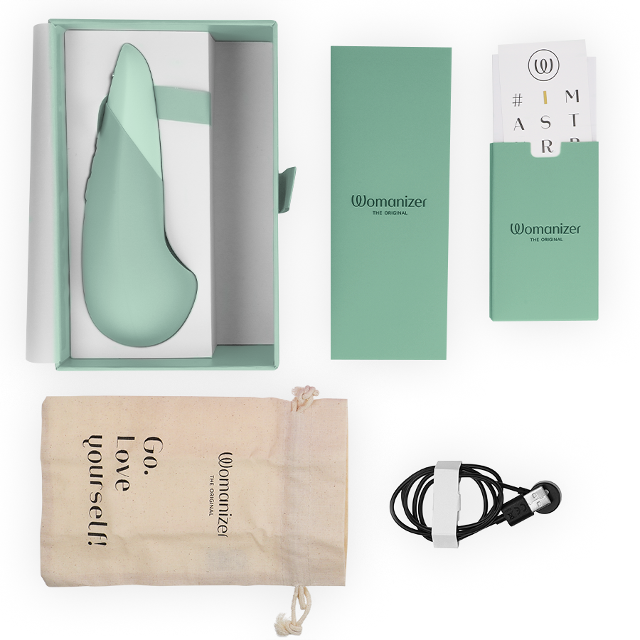 Vibromasseur à poser UltraWave Vibe vert sauge présenté avec son écrin, câble de charge magnétique, pochette Go love yourself et cartes d'accessoires sur fond clair.