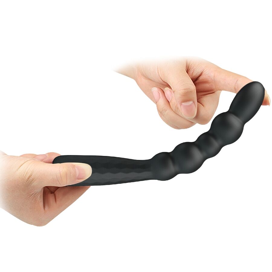 Plug anal Mr Play en silicone noir tenu et flechi entre deux mains, demontrant la souplesse de la tige ondulee perlee qui epouse les courbes pour un confort optimal