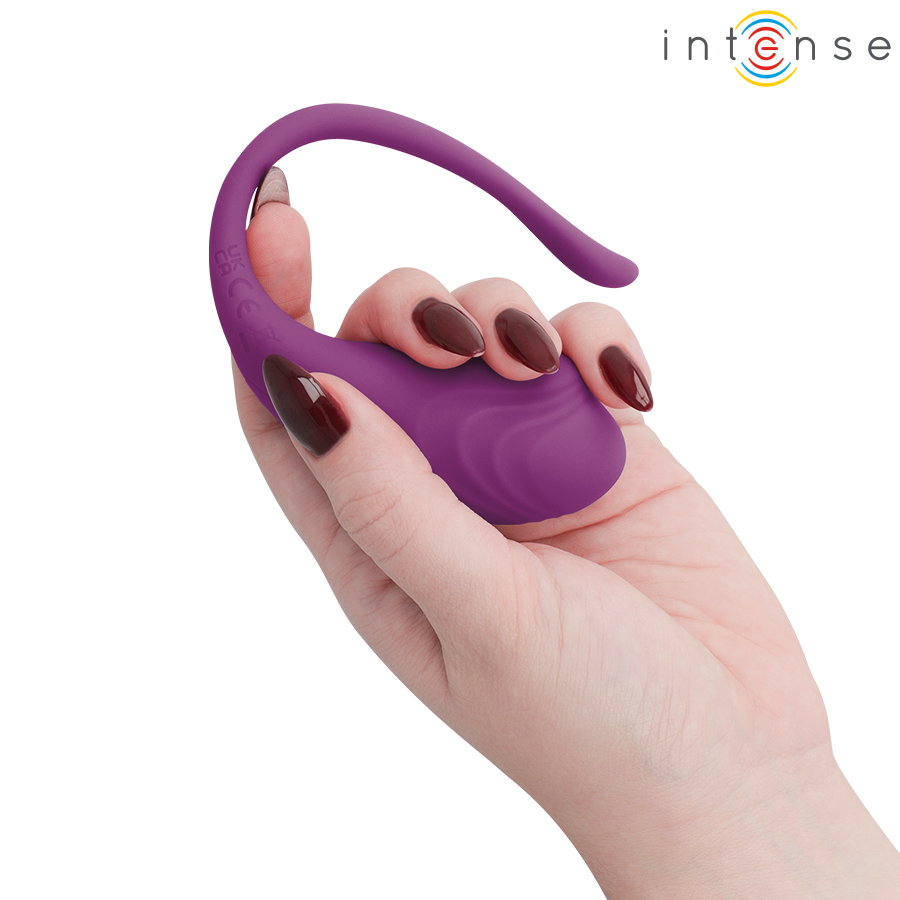 Oeuf vibrant Olivia Intense en silicone violet plie par une main aux ongles fonces, illustrant la souplesse de sa longue tige flexible recourbee