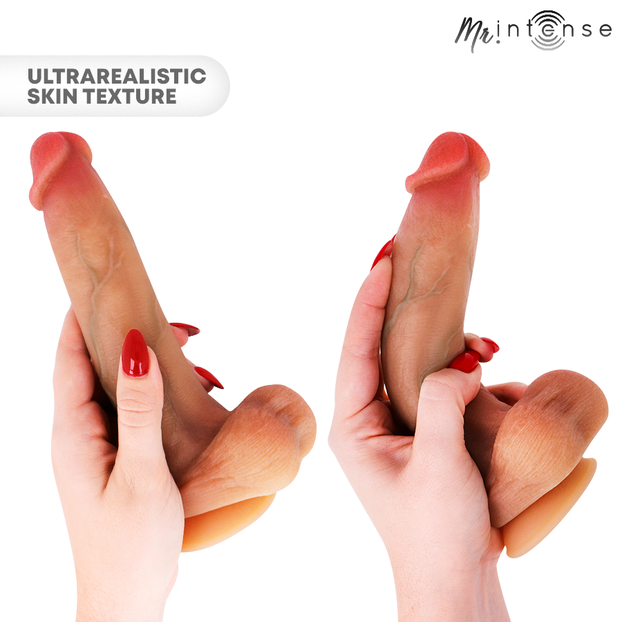 Bruce M gode en silicone avec testicules — tenu à deux mains, gros plan sur la texture de peau réaliste, ongles rouges