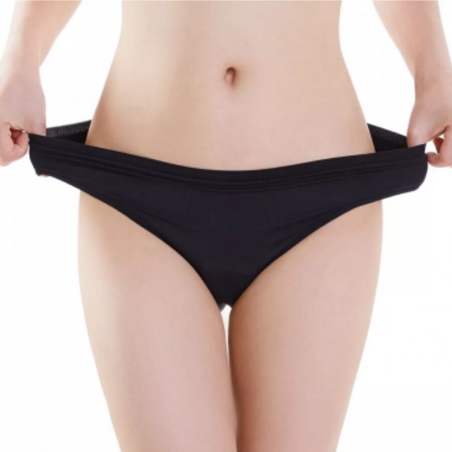 Culotte menstruelle noire portee de face, mains etirant le tissu elastique, protection absorbante anti-fuites lavable equivalente a trois tampons