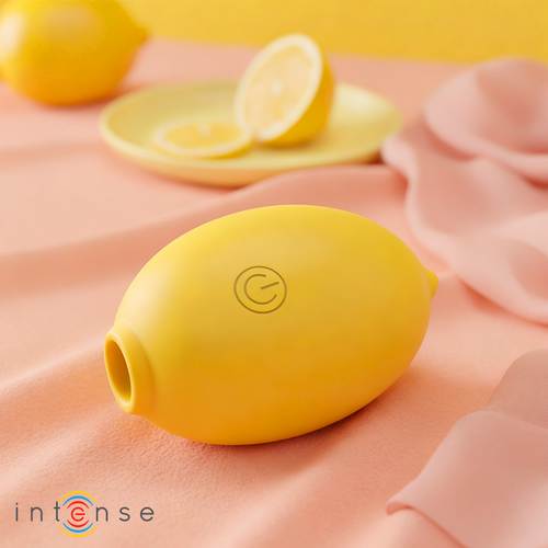 Stimulateur clitoridien citron Intense posé sur tissu pastel avec rondelles de citron, format compact en silicone pour une aspiration douce sur le clitoris.